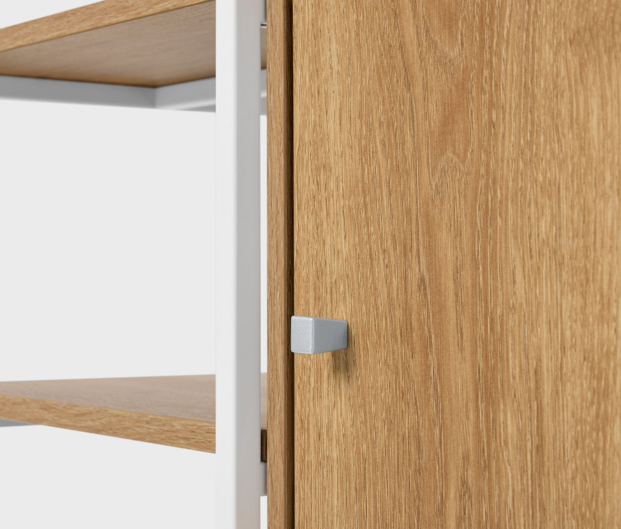 Detailný pohľad na regál s drevenými policami a drevenými dverami so štvorcovou striebornou rukoväťou.