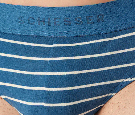 Muž má na sebe modro-biele pruhované slipy SCHIESSER Rio. Modrý pás má logo SCHIESSER.