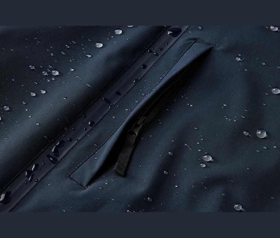Tmavomodrá, vodoodolná látka s kvapkami vody a vreckom na zips.