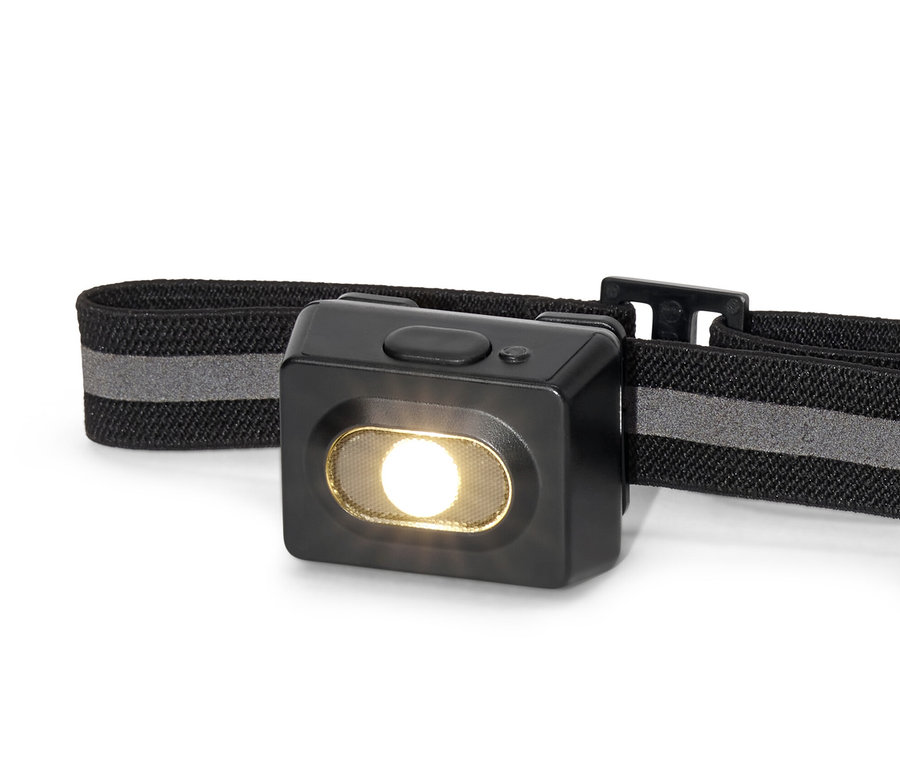 Detailný záber na čiernu čelovú lampu.