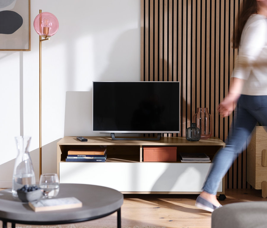 Obývacia izba s stojacou lampou »Sklenená guľa« a skrinkou pod televízor s kolieskami.