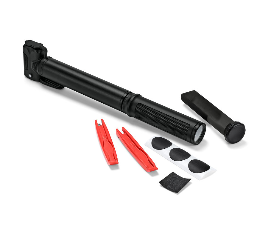 Čierna pumpička na bicykel leží vedľa dvoch červených montážnych pák, záplat a brúsneho papiera.