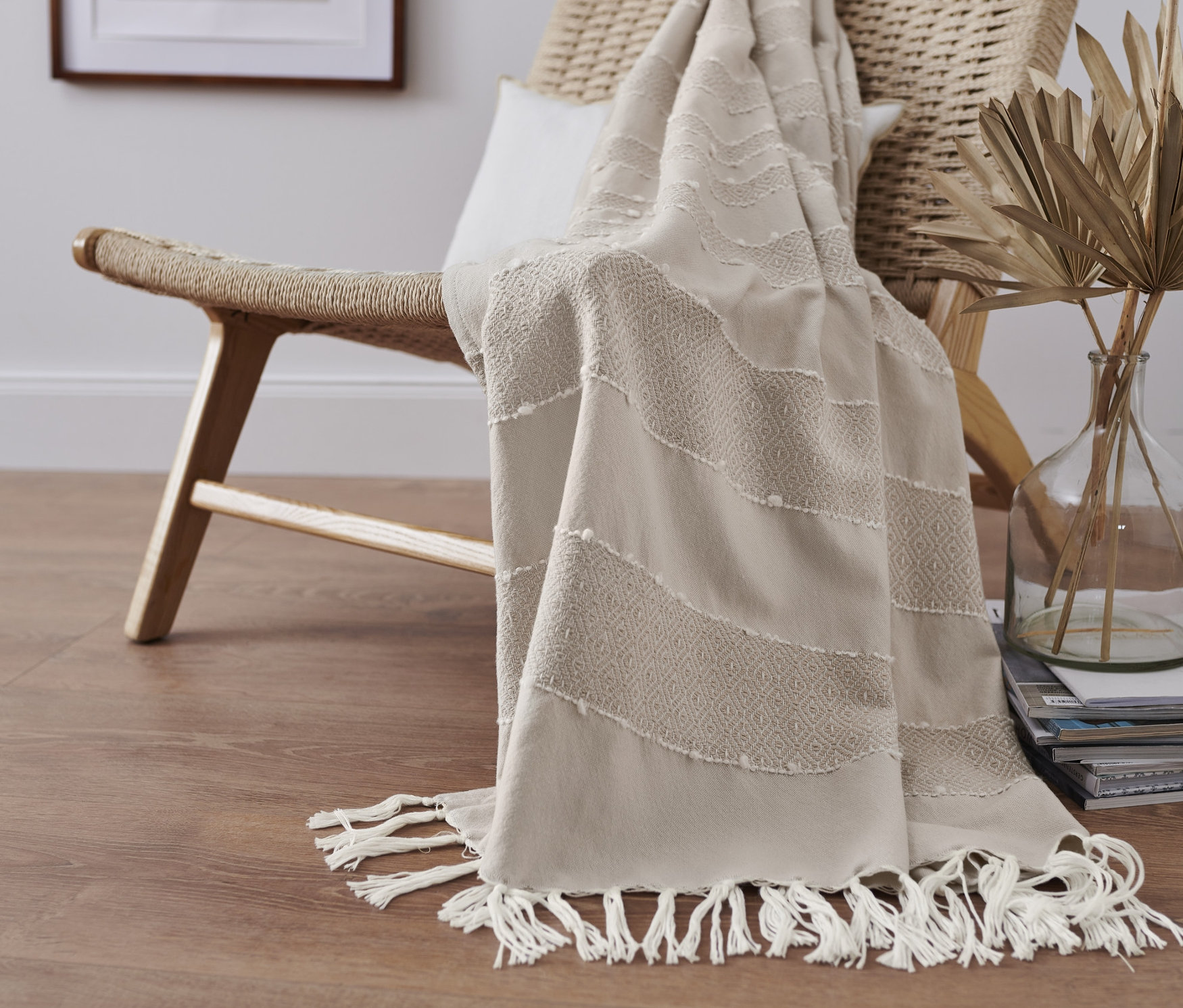 Na prútenom kresle leží béžová deka.