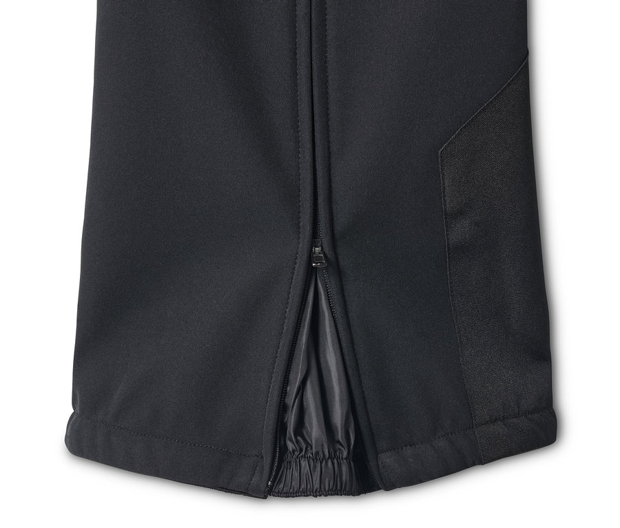 Detail čiernych lyžiarskych nohavíc so zipsom pri členku.