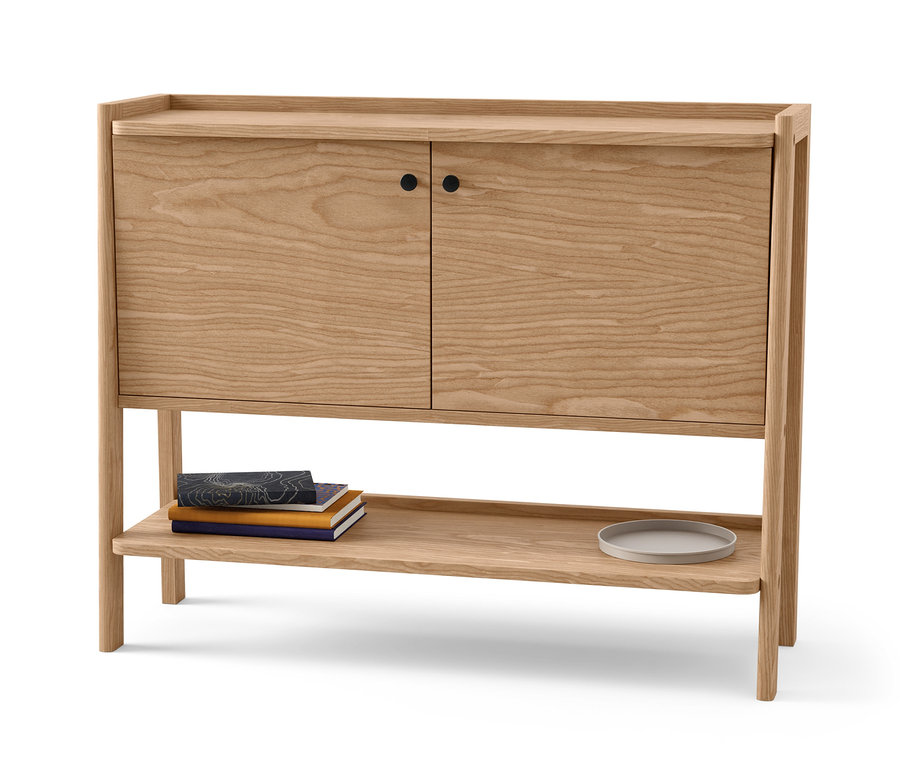 Drevený príborník s dvomi dvierkami a policou. Na polici ležia knihy a tanier.