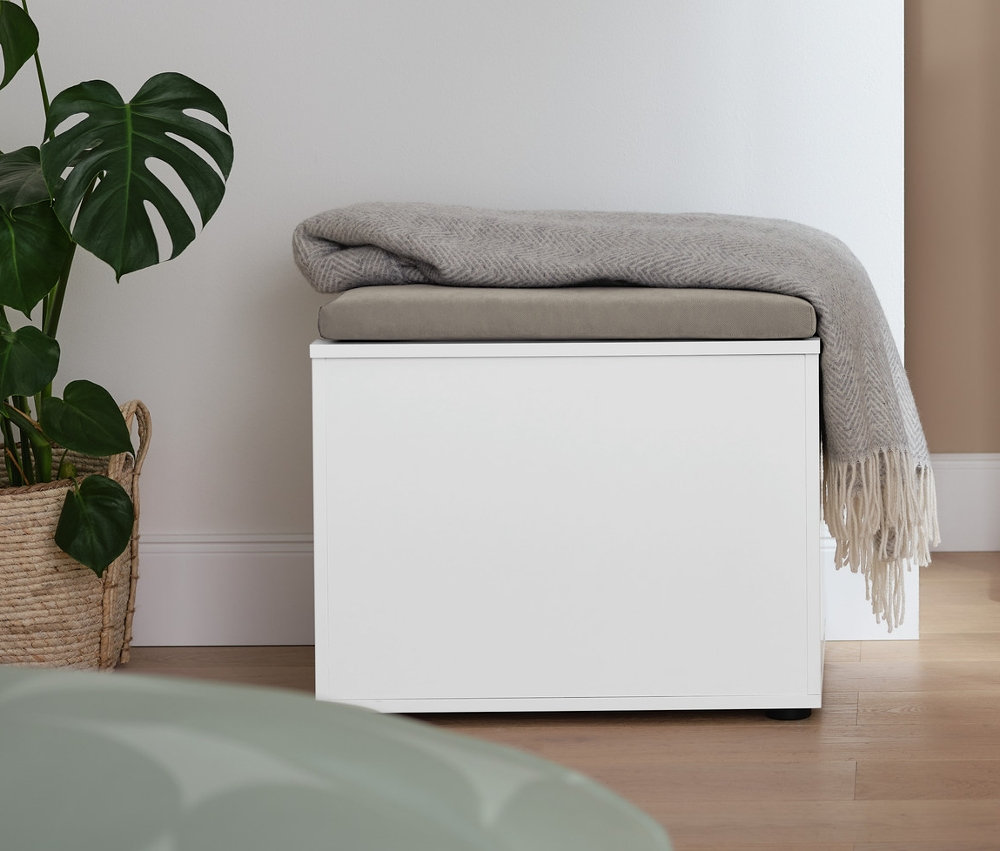 V izbe stojí nemý sluha a truhlica s miestom na sedenie, na ktorej leží deka.