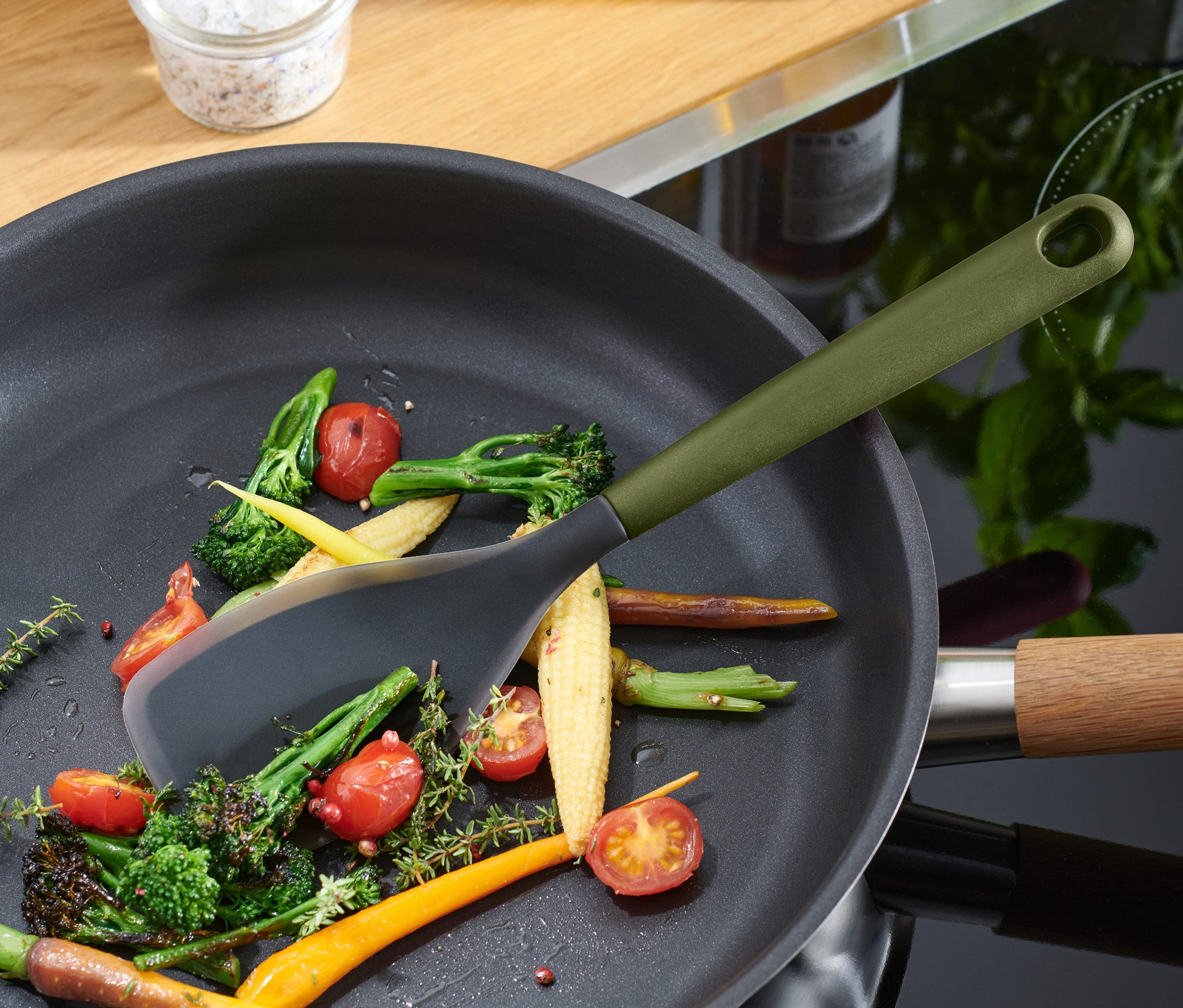 Multifunkčná vareška mieša zeleninu na panvici.