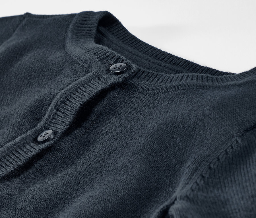 Detailný pohľad na detský pletený svetrík s gombíkmi.