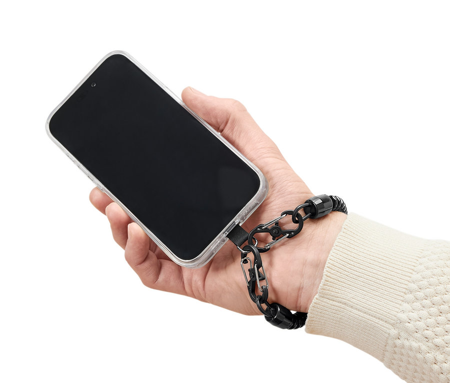 Ruka drží mobilný telefón s priehľadným puzdrom a čiernou bezpečnostnou retiazkou.