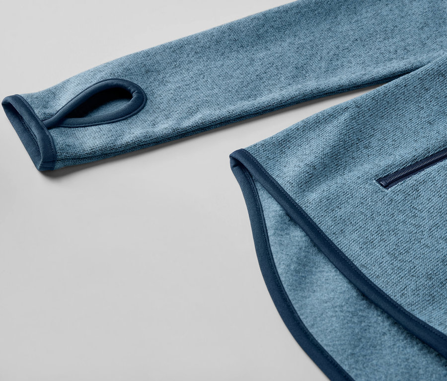 Detail tmavomodrej bundy z pleteného flaušu s otvorom na palec.