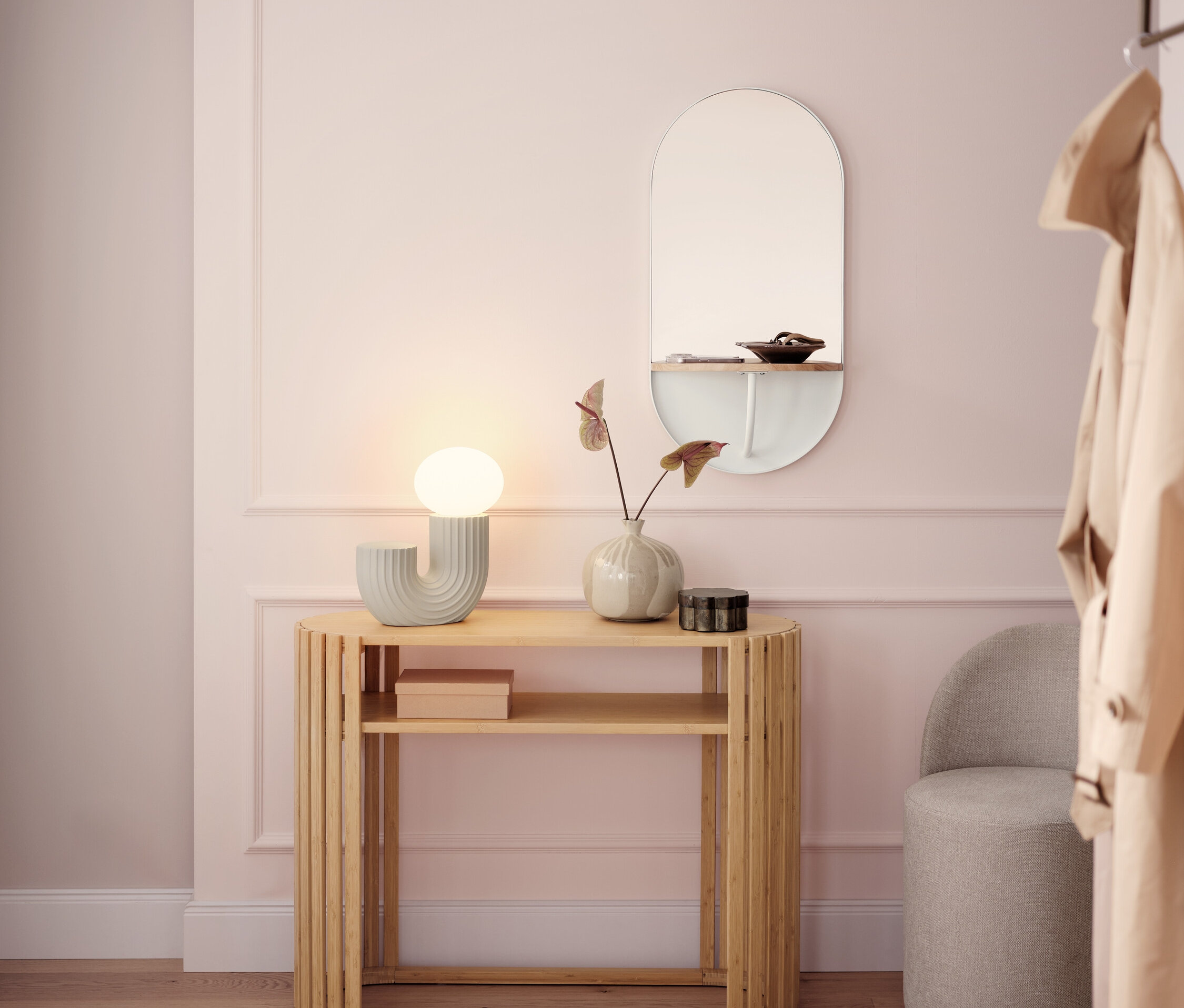 Svetlá chodba s dreveným konzolovým stolíkom, lampou, zrkadlom a sivou stoličkou.