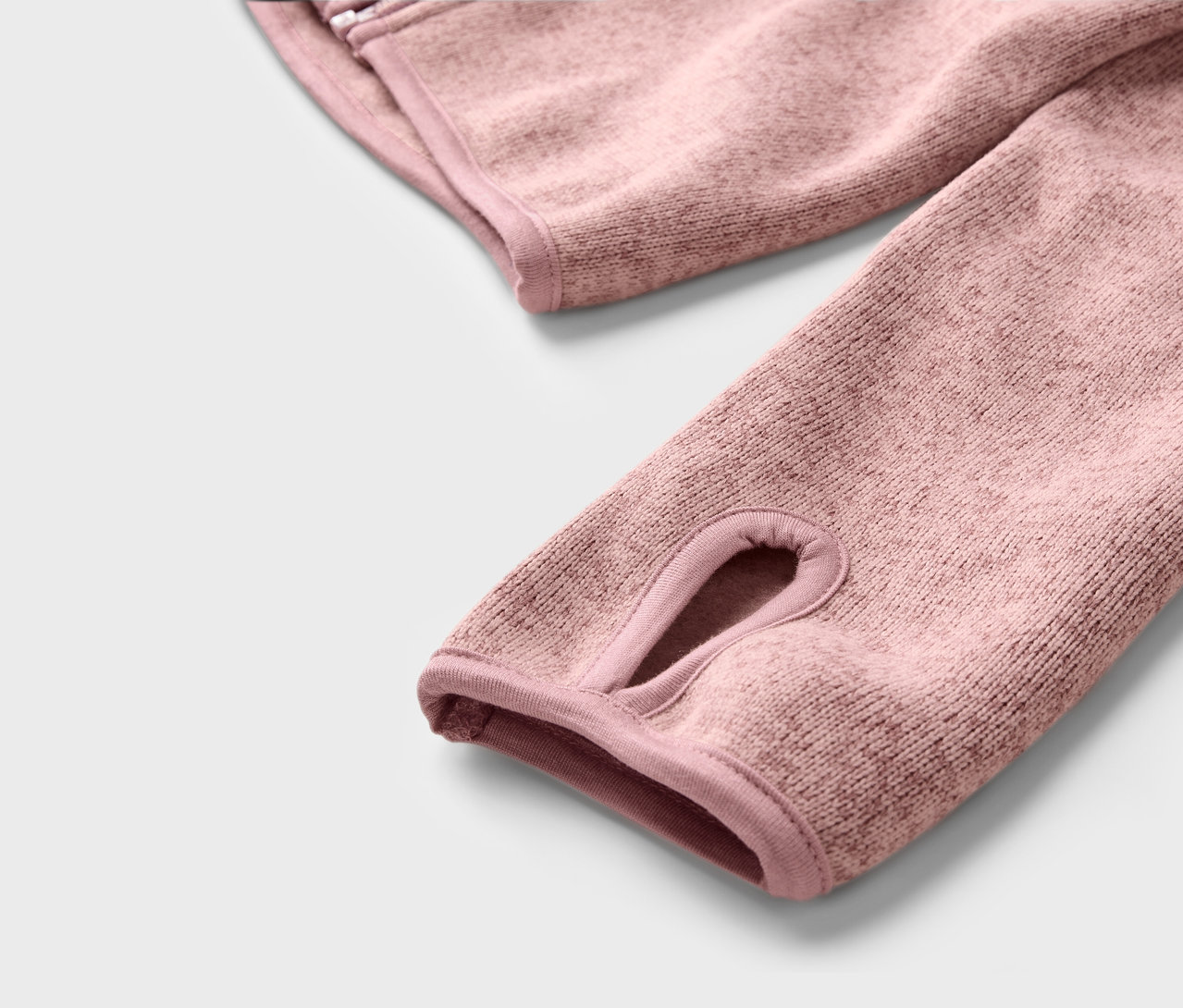 Detail detskej mikiny z pleteného fleecu s otvorom na palec.