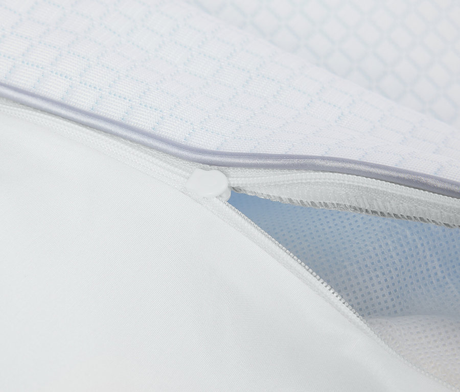 Detailný pohľad na čiastočne otvorený, biely zips na obliečke na vankúš.