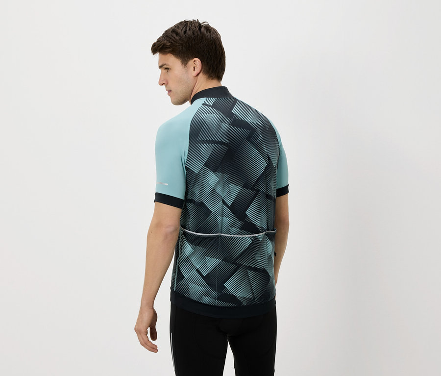 Muž zozadu v modro-čiernom cyklistickom drese a čiernych nohaviciach na bielom pozadí.