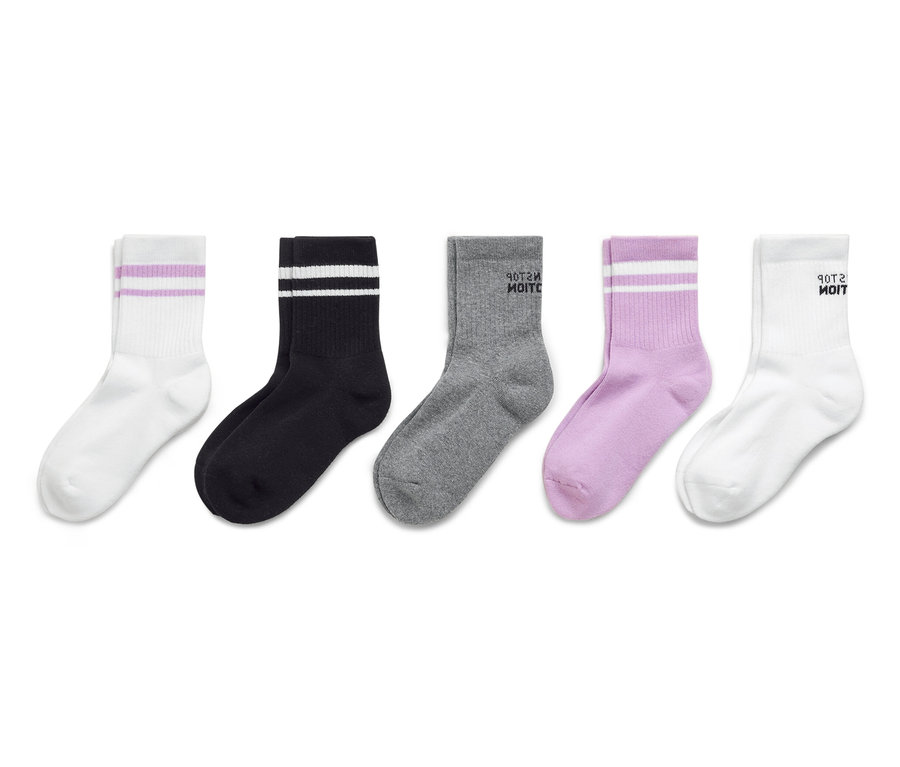 Päť ponožiek leží vedľa seba: biela ponožka s fialovými pruhmi, čierna ponožka s bielymi pruhmi, sivá ponožka s textom „Vezmi si ma“, fialová ponožka s bielymi pruhmi a biela ponožka s textom „Vezmi si ma“.