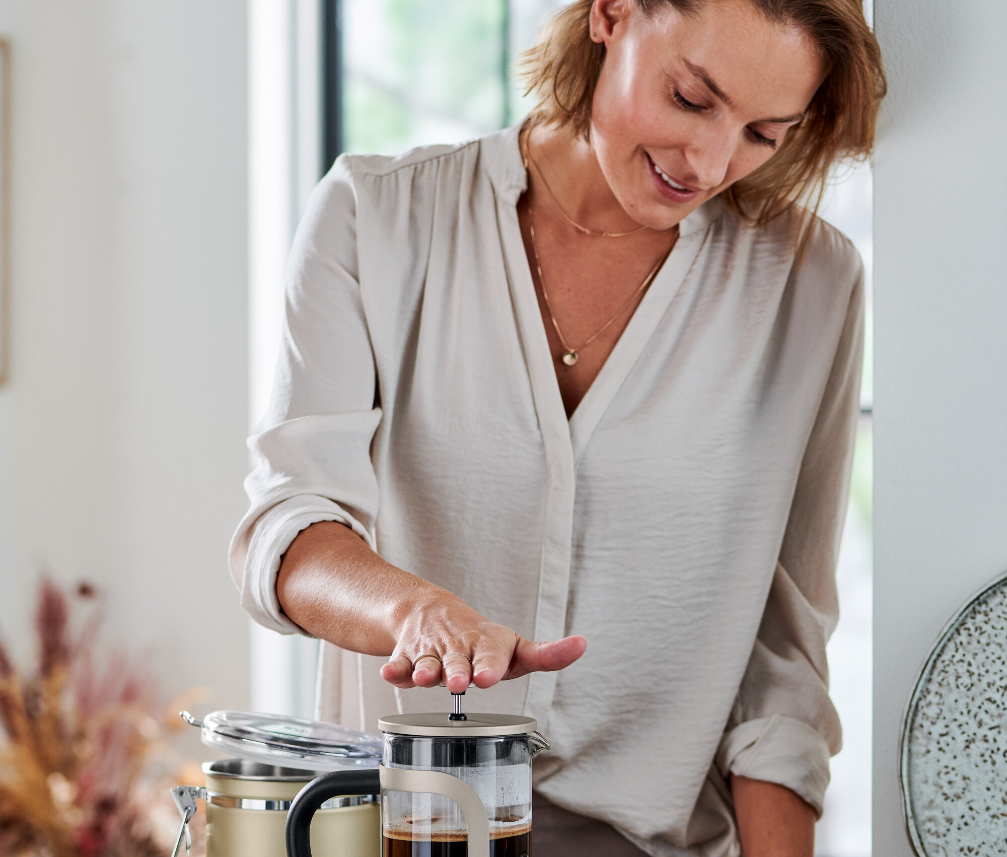 Žena stláča kanvicu french press 800 ml, 6 šálok, farba šampanského.