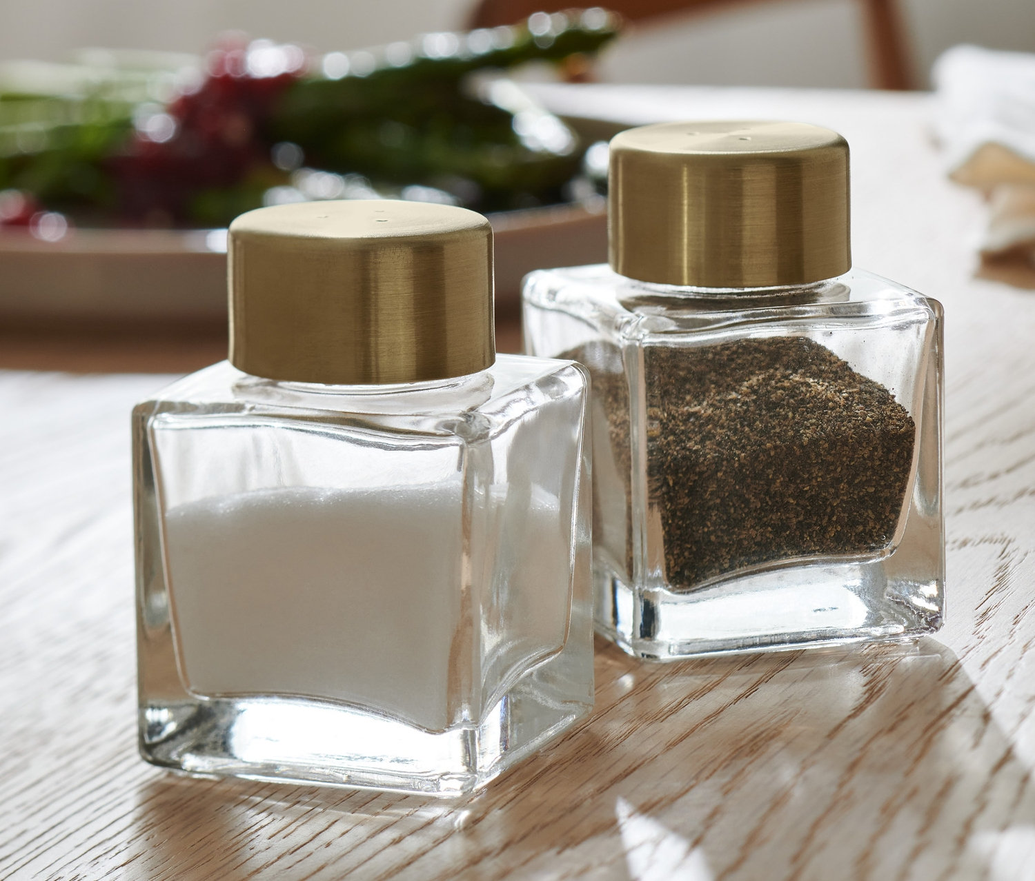 Na drevenom stole stojí soľnička a korenička.