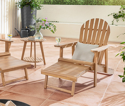 Dvojité a samostatné Adirondack relaxačné kreslo s vyťahovacou opierkou nôh stojí na terase s outdoorové vankúše na dotyk pripomínajúce ľan.