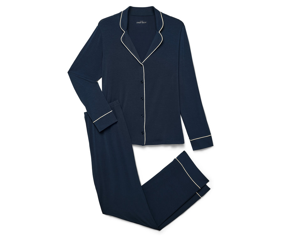 Tmavo modré pyžamo s dlhým rukávom a nohavicami s bielym lemovaním na bielom pozadí.