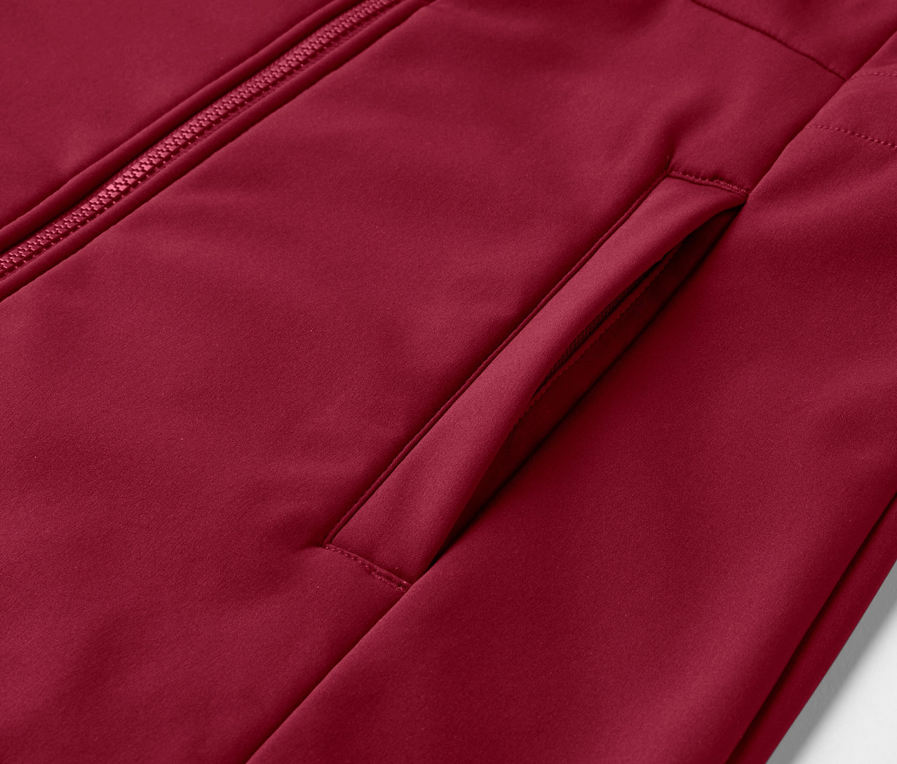 Detail softshellového kabáta v tmavočervenej farbe.