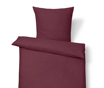 Ľanové obliečky štandardnej veľkosti vo farbe bobúľ s vankúšom navrchu.