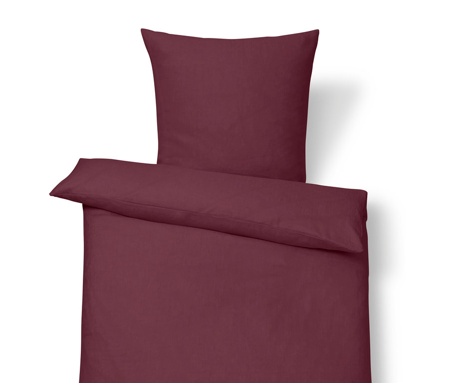 Ľanové obliečky štandardnej veľkosti vo farbe bobúľ s vankúšom navrchu.