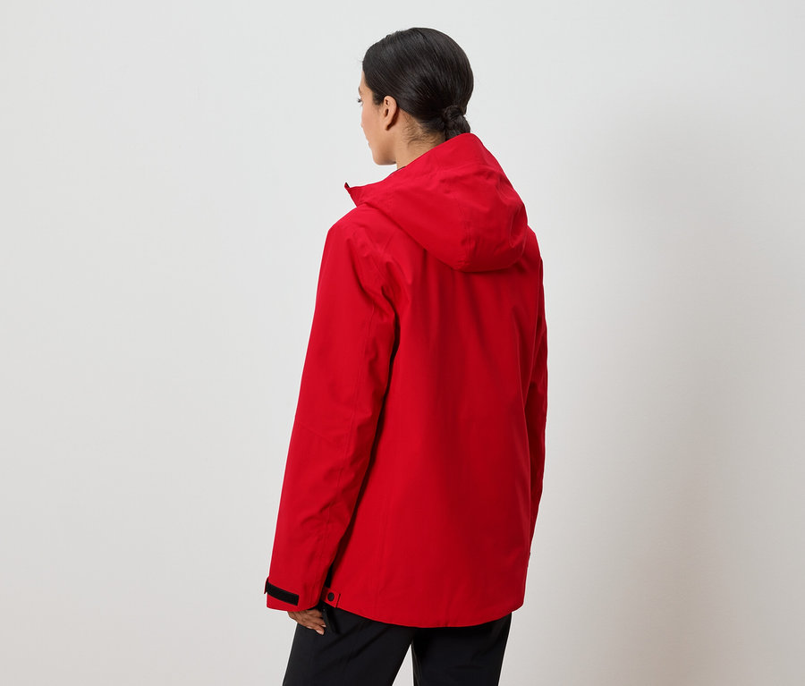 Žena chrbtom k fotoaparátu má na sebe červenú bundu s kapucňou.