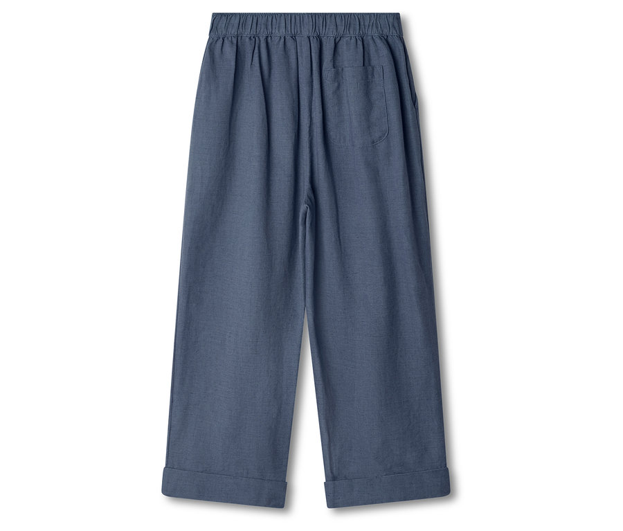 Na bielom pozadí sú modré nohavice.