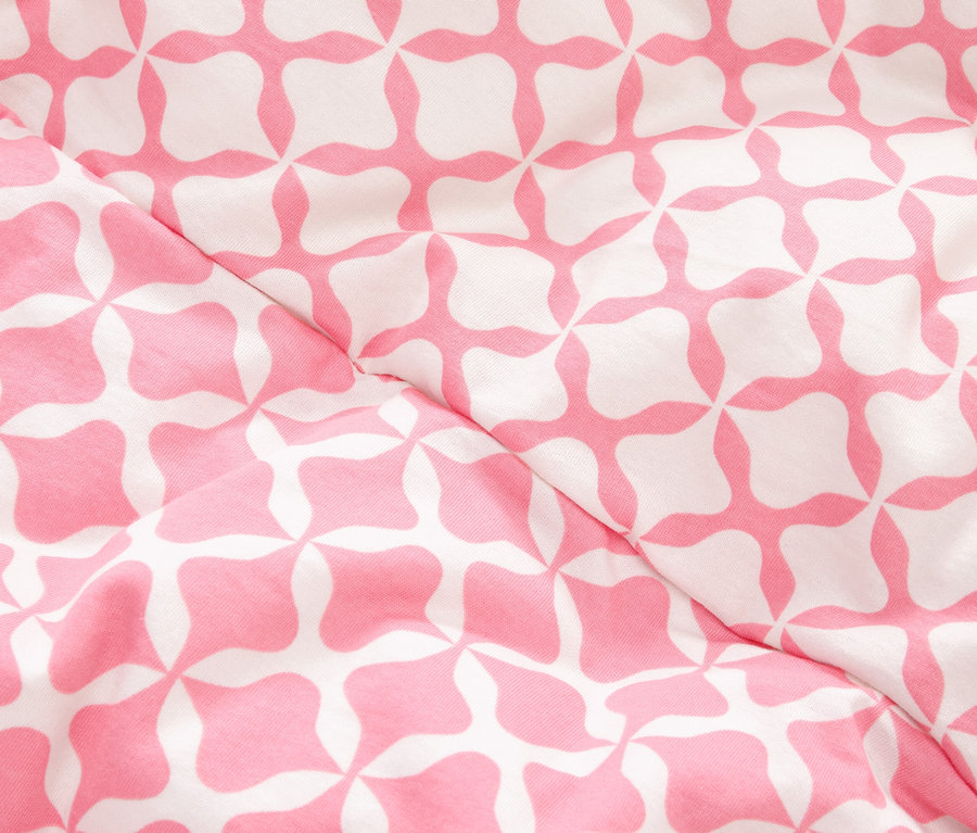 Detail látky s ružovým a bielym geometrickým vzorom.