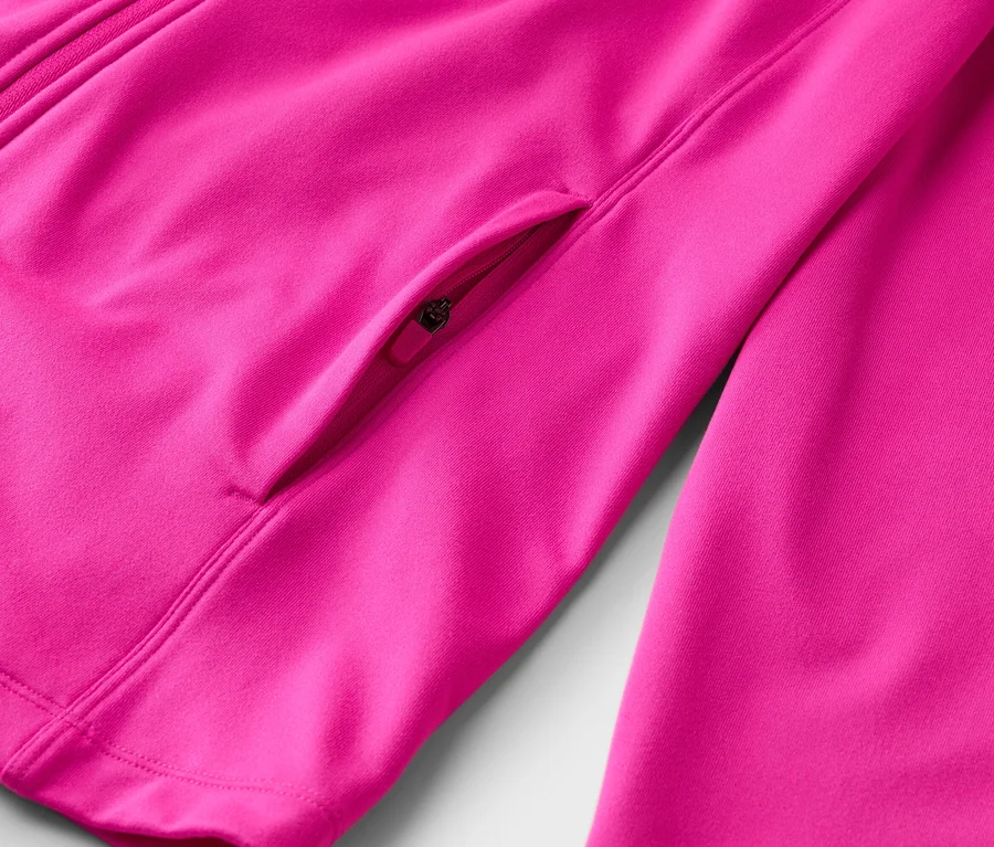 Detail ružovej bundy so zipsom a malým vreckom na zips.