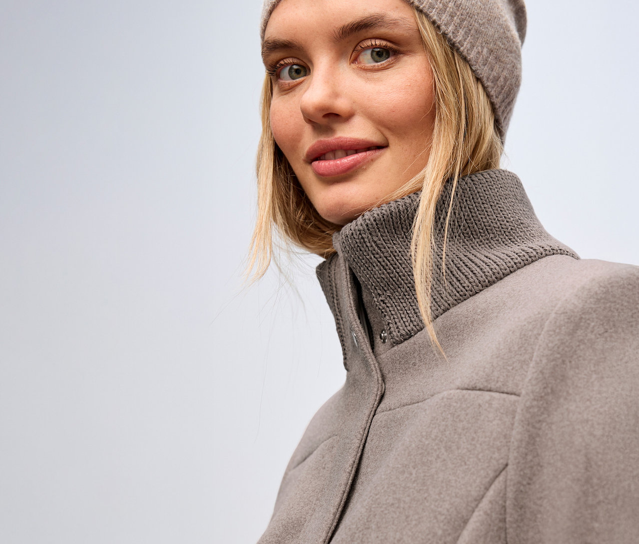 Žena má na sebe krátky kabát Street One a čiapku.