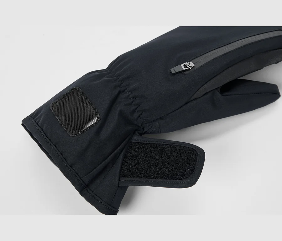 Detail čiernej zimnej palčiaky s vreckom na zips na chrbte ruky, nastaviteľným suchým zipsom na zápästí a elastickou manžetou s čiernou textúrovanou nášivkou.
