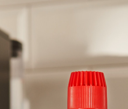 Čierna fľaša odvápňovača durgol® špeciálny odvápňovač, 400 ml stojí na linke vedľa kávovaru.
