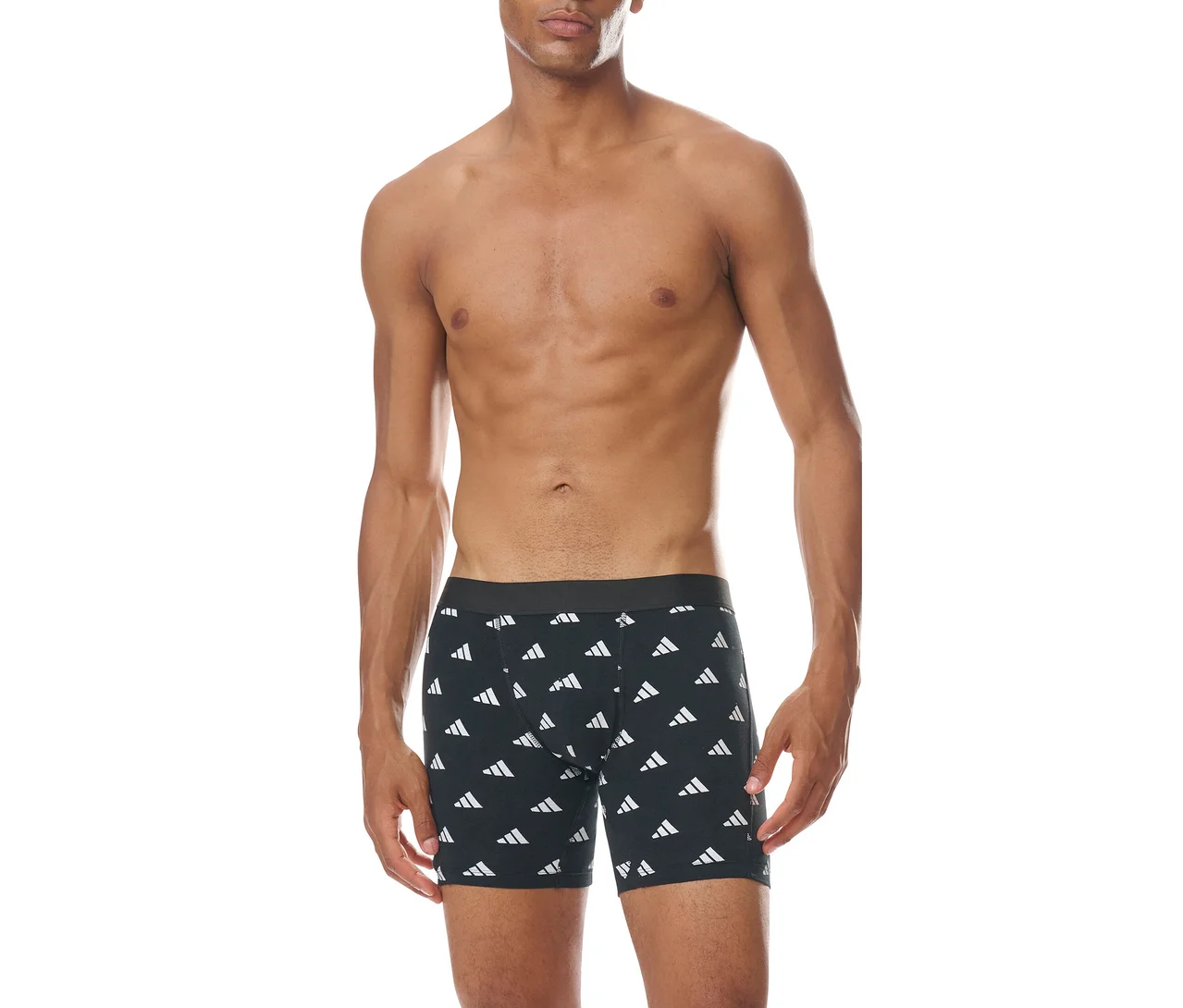 Muž bez trička stojí spredu, oblečený v čiernych boxerkách s opakujúcim sa bielym vzorom loga Adidas.