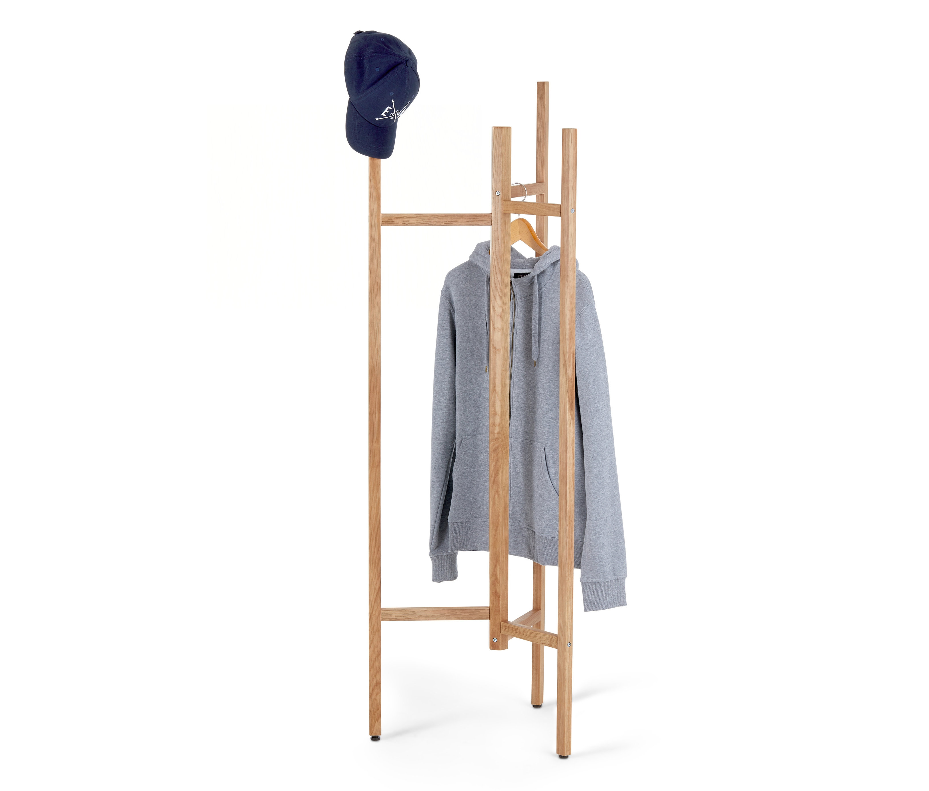 Modrá šiltovka leží na vrchu dreveného vešiaka, na ktorom visí sivá mikina na zips.