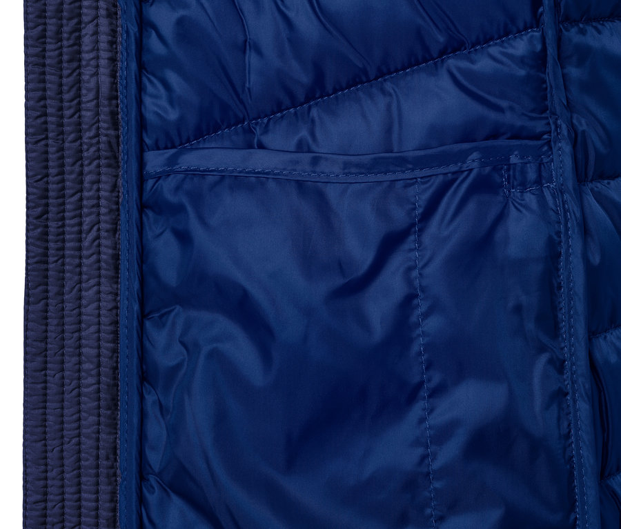 Detail modrej prešívanej bundy s vreckom.