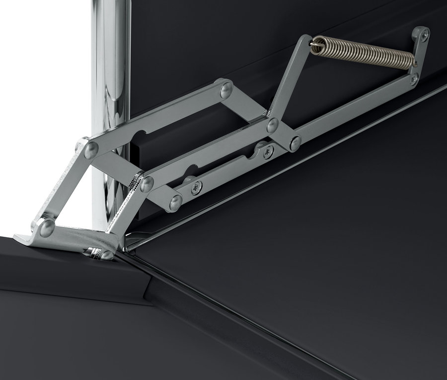 Detail mechanizmu výklopných dvierok čierneho kovového kontajnera na kolieskach »CN3«.