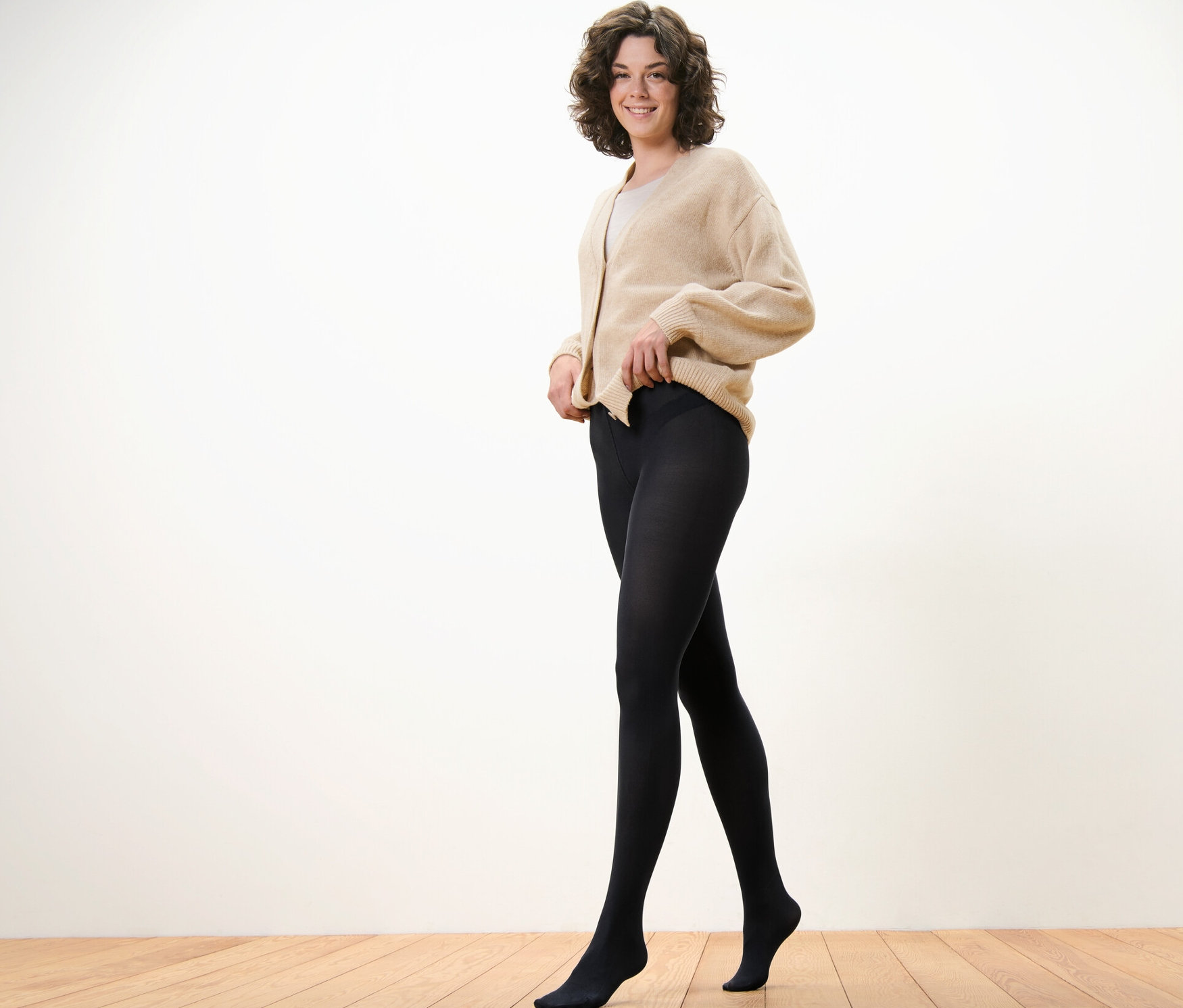 Žena si upravuje čierne, jemné pančuchové nohavice 80 DEN.