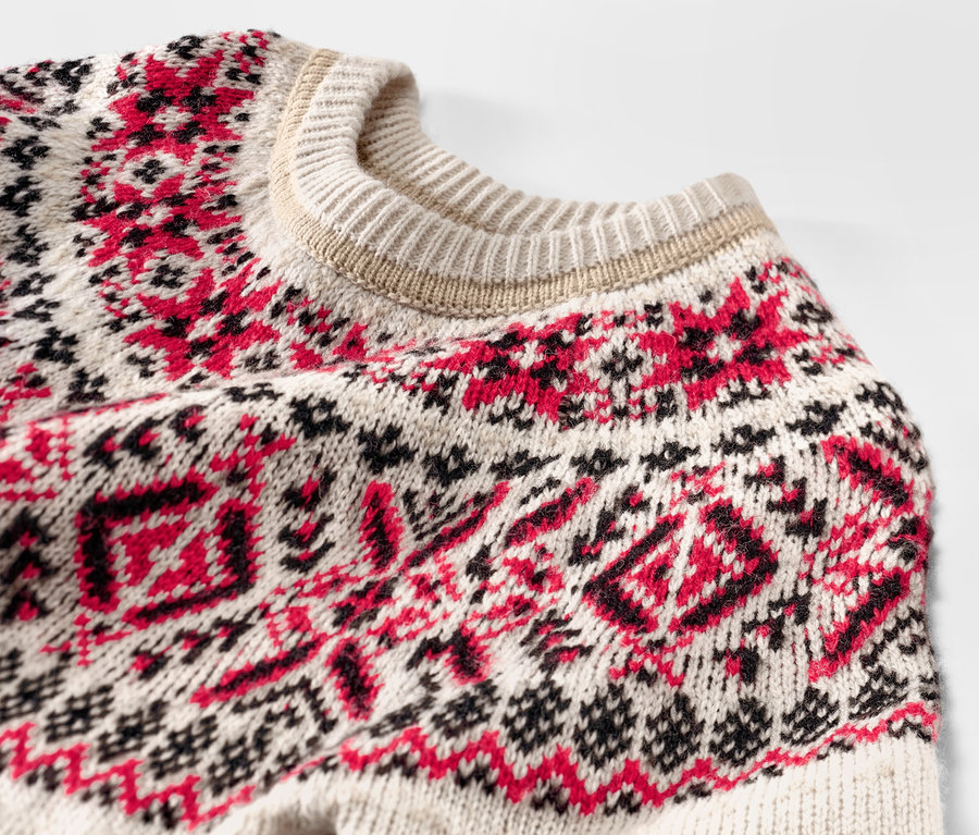 Detail detského pleteného svetra s nórskym vzorom.