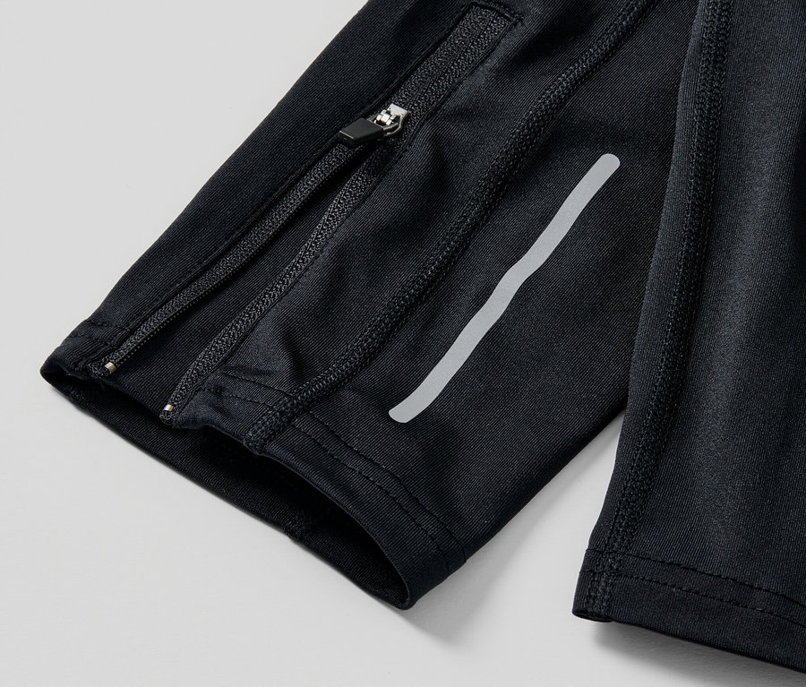 Detail čiernych bežeckých legíns so zipsom a reflexným prúžkom.