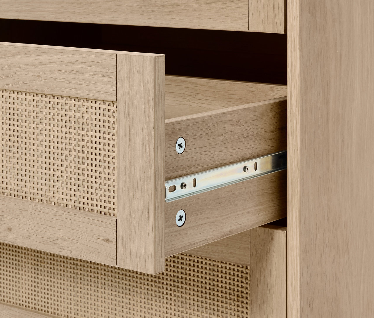 Detail komody s otvorenou prútenou zásuvkou.