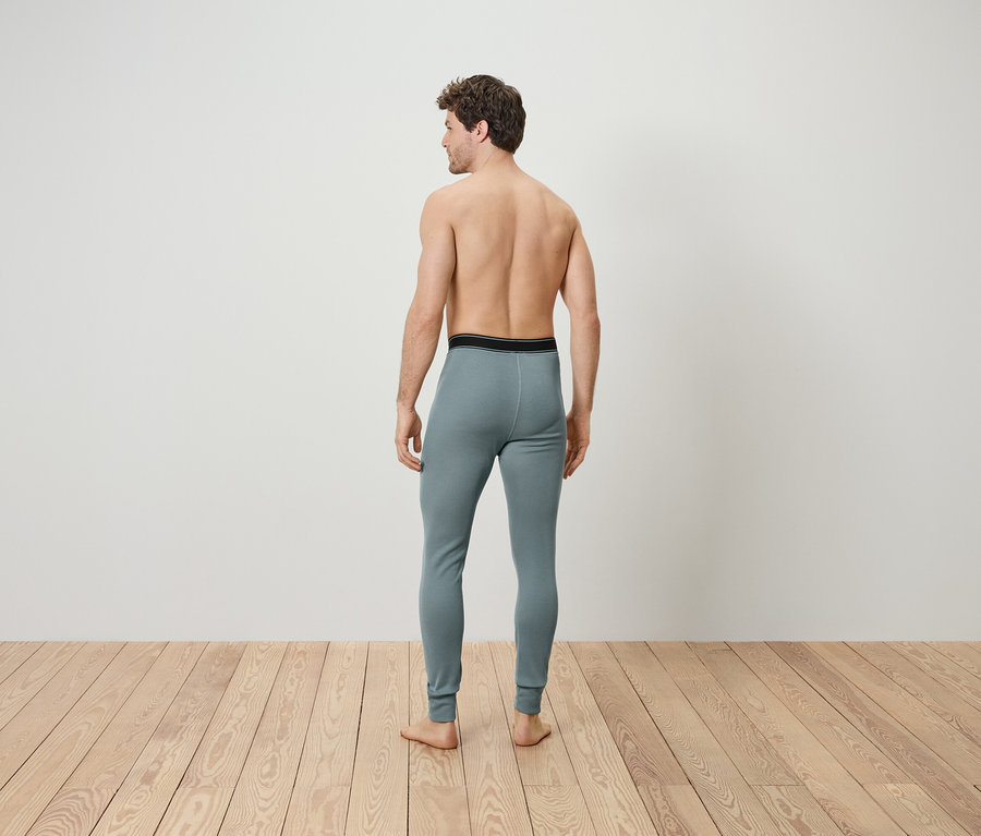 Muž chrbtom k fotoaparátu má na sebe sivú termobielizeň.