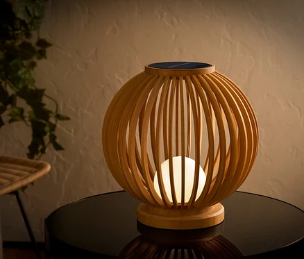 Dekoratívna solárna lampa z dreva na stole.