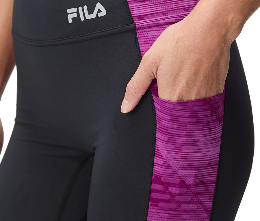 Žena má na sebe čierne legíny s ružovým vzorom a logom Fila.