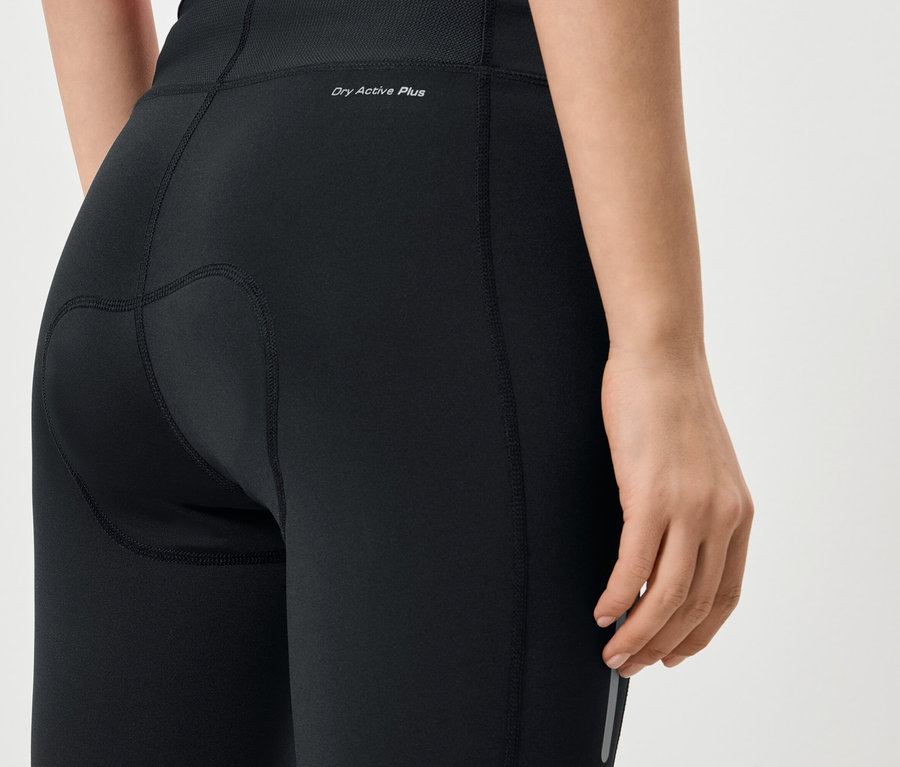 Detailný záber na zadnú časť ženy v čiernych legínach s nápisom „Dry Active Plus“.