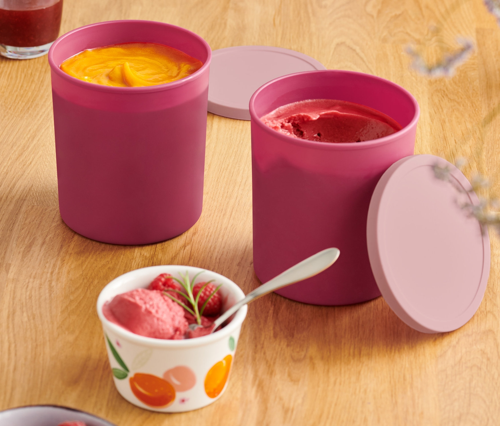 Dve dózy do mrazničky s obsahom a viečkami na drevenom stole.