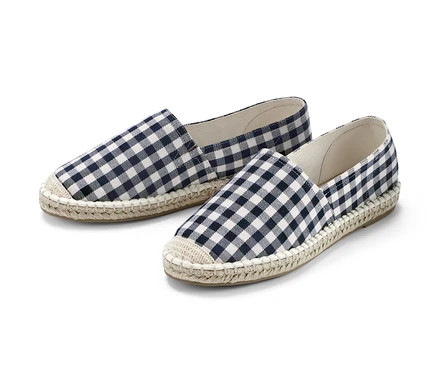 Dvoje espadrilky s tmavomodrým a bielym kockovaným vzorom.