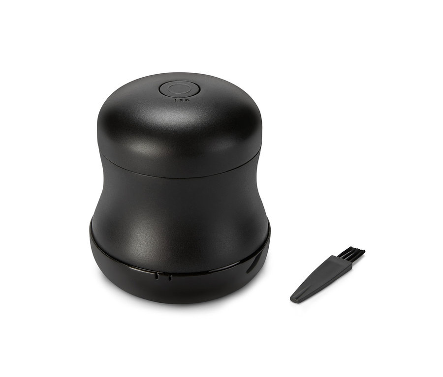 Čierny odstraňovač žmolkov a čistiaca kefka na bielom pozadí.