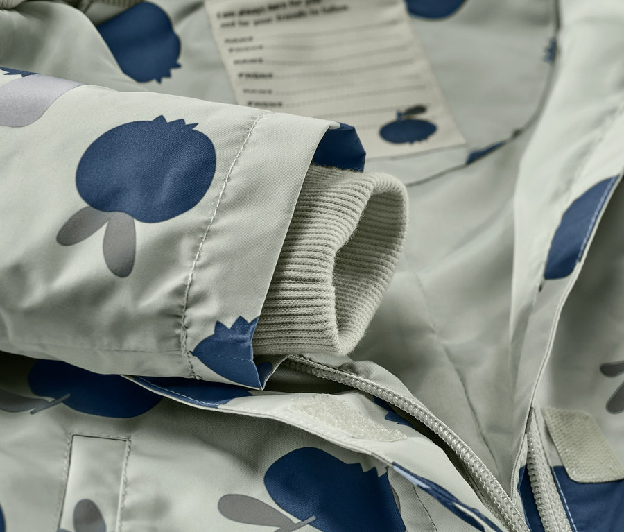 Detail detského overalu do dažďa s potlačou čučoriedok.