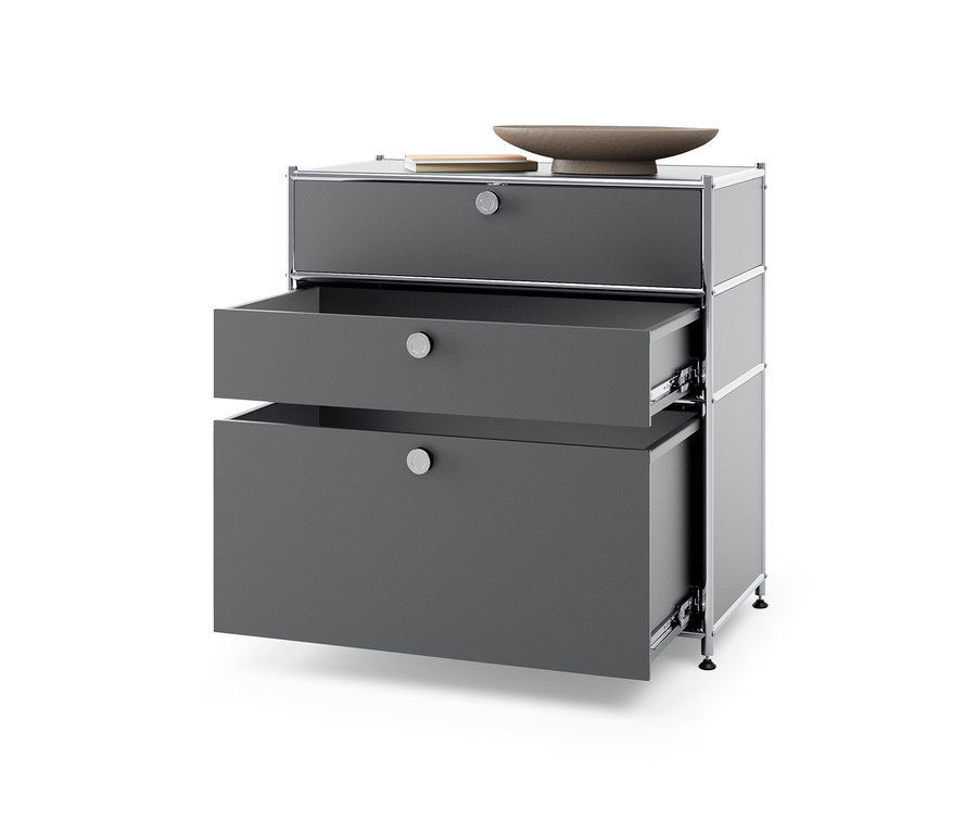 Sivá kovová komoda »CN3« s 3 zásuvkami, z ktorých dve sú otvorené.